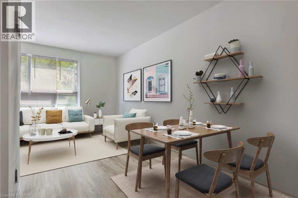 A dining room with a table set for two and a couch with a pillow in the background.