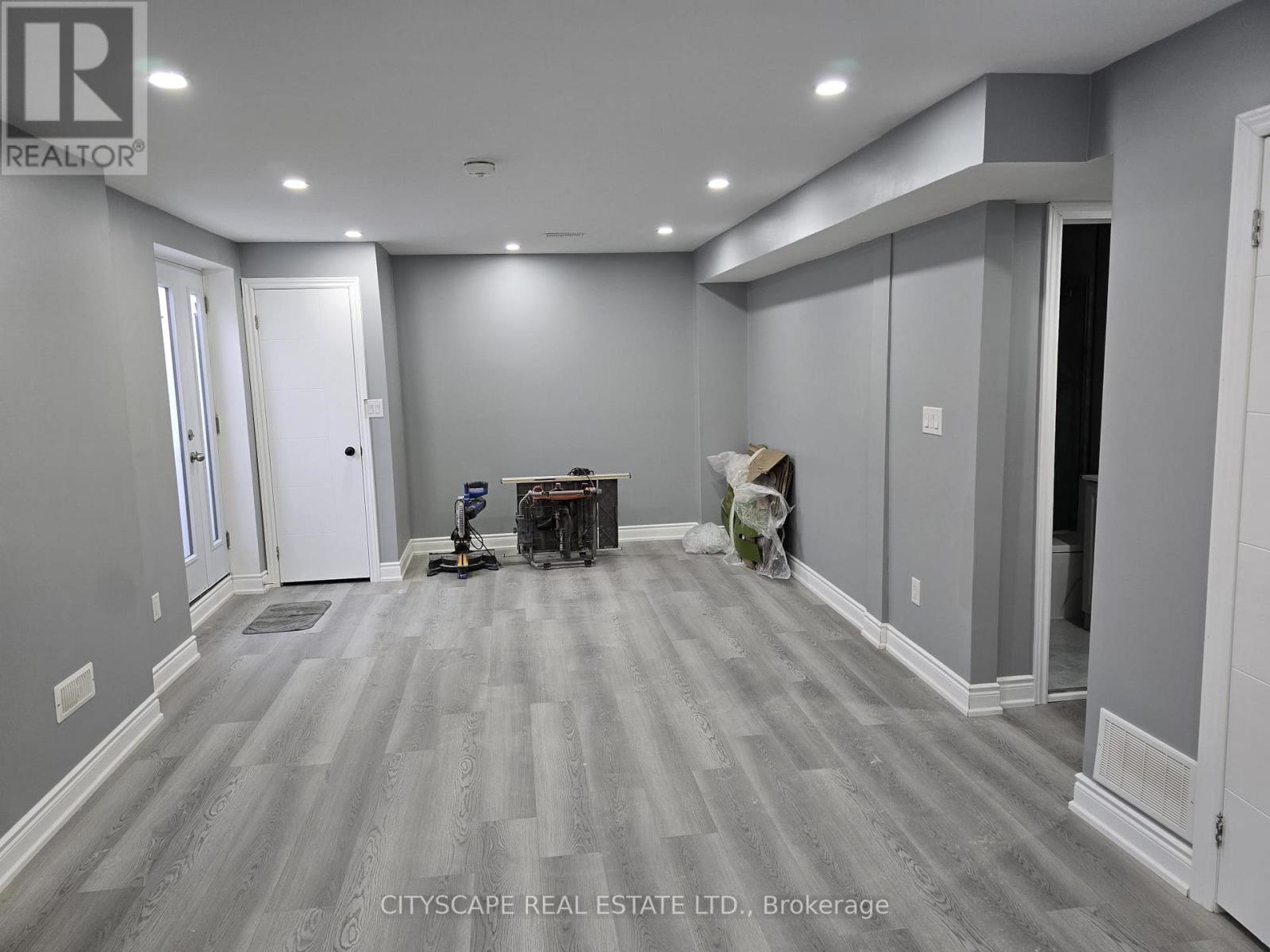A room with grey walls and wooden flooring is under renovation.