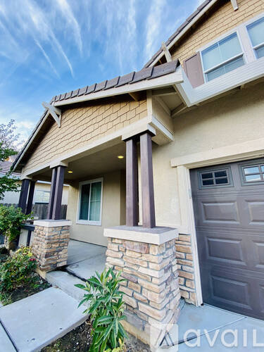 A house with a brown roof and a grey garage door.