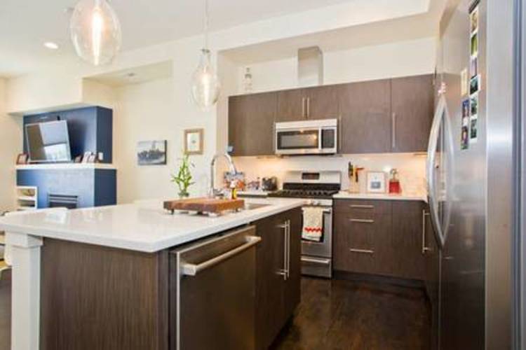 A modern kitchen with dark brown cabinets and stainless steel appliances.