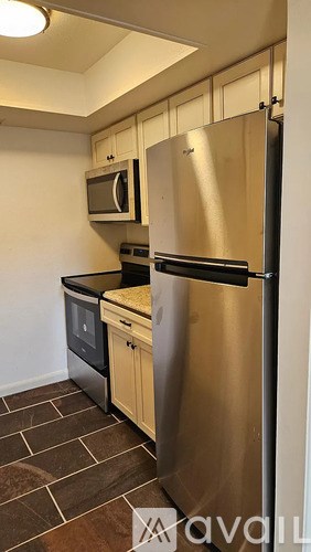 A kitchen with a stainless steel refrigerator and microwave.