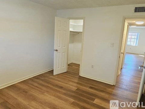 A room with wooden flooring and a white door.
