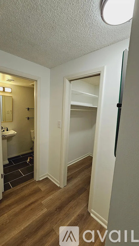 A room with a white door and a wooden floor.