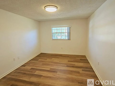 A room with wooden flooring and a window.