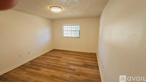 A room with wooden flooring and a window.