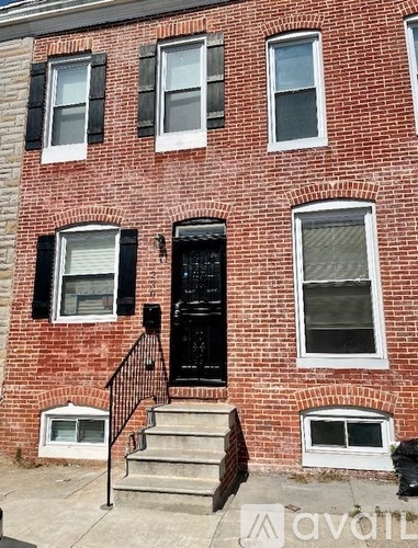 A red brick building with a black door and windows.