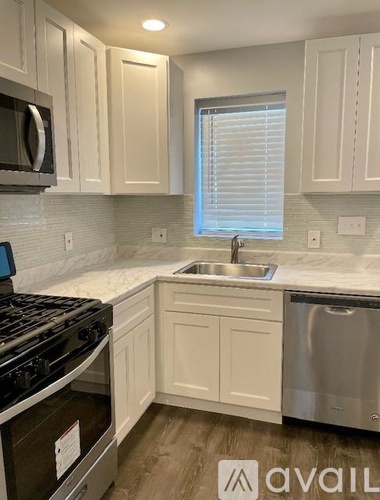 A kitchen with white cabinets and a stainless steel dishwasher.