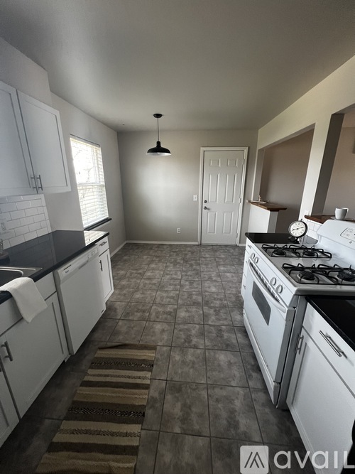 A kitchen with white cabinets and a black stove top oven.