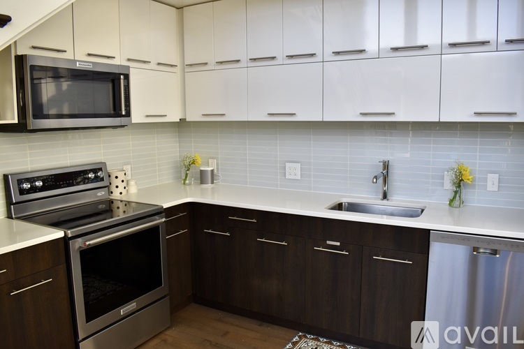 A kitchen with a stainless steel oven and a white microwave above it.