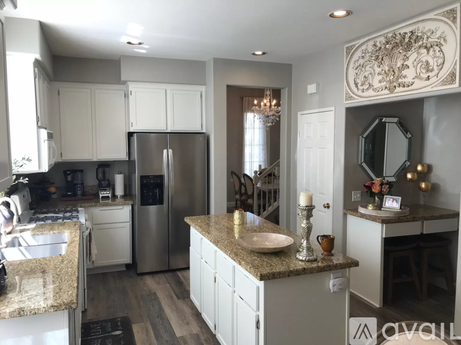 A kitchen with a granite countertop and stainless steel appliances.