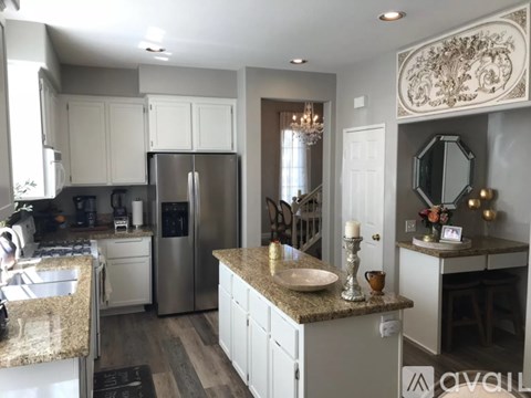 A kitchen with a granite countertop and stainless steel appliances.