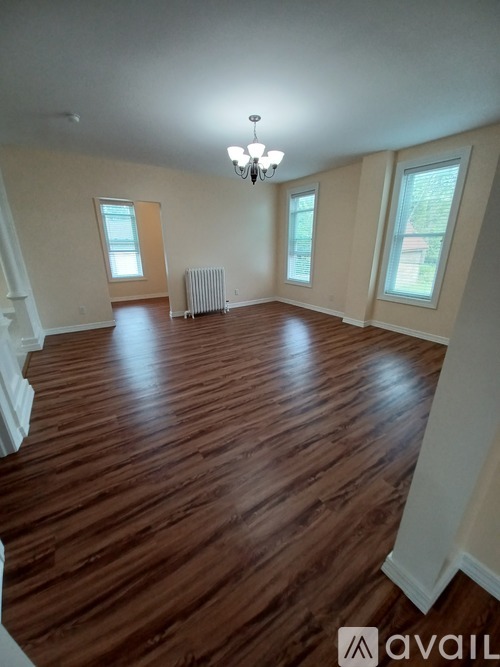 A room with wooden floors and a chandelier.