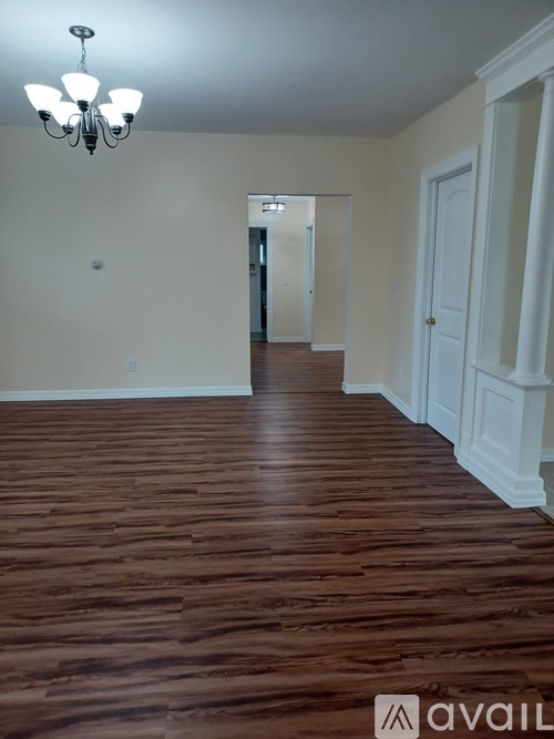 A room with wooden floors and a chandelier.