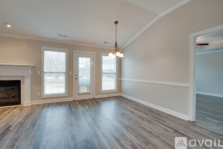 A spacious room with a fireplace and a chandelier.