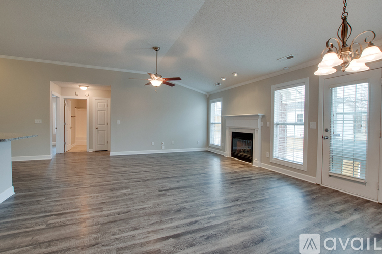 A spacious living room with wood flooring and a fireplace.