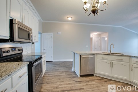 A kitchen with white cabinets and a granite countertop.