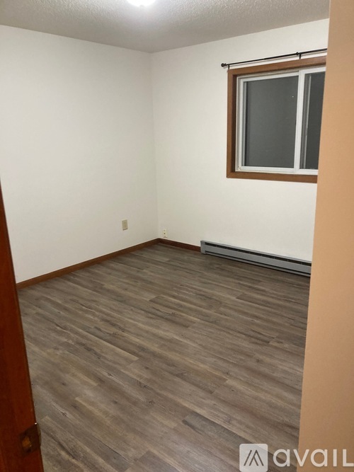 A room with wooden flooring and a window.