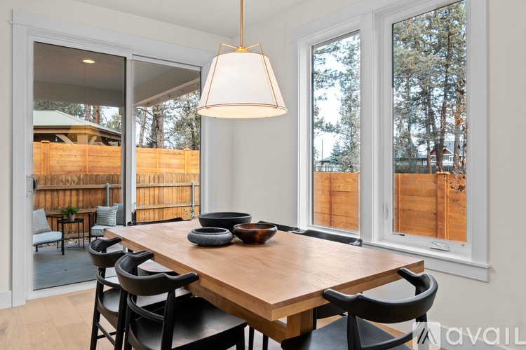 A dining room with a wooden table and chairs.
