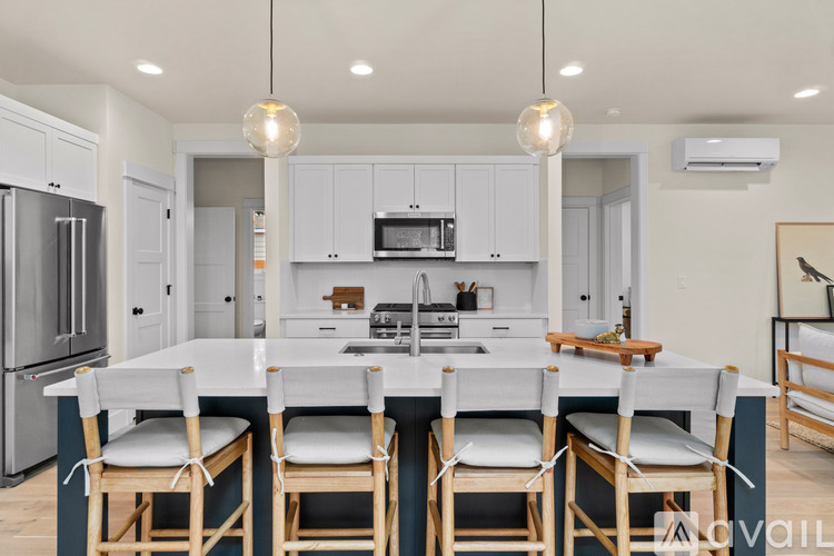 A kitchen with a table and chairs in front of it.