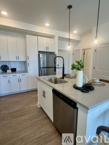 A kitchen with white cabinets and a black dishwasher.
