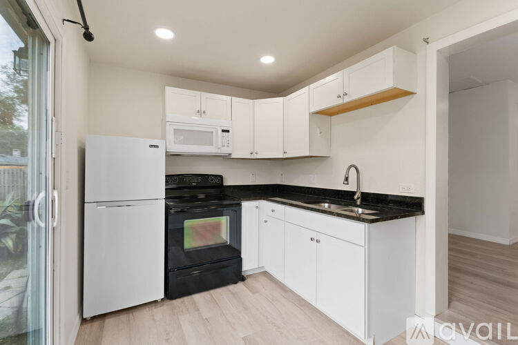 A kitchen with white cabinets and appliances.