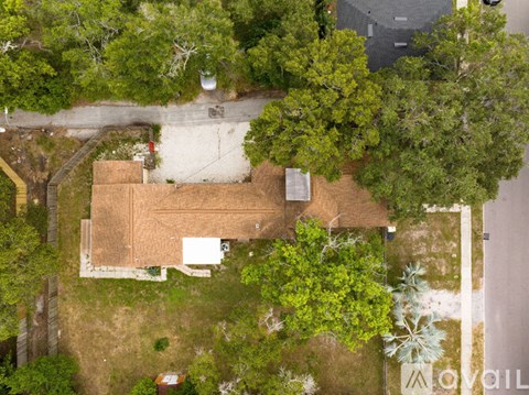 A house surrounded by trees from an aerial view.