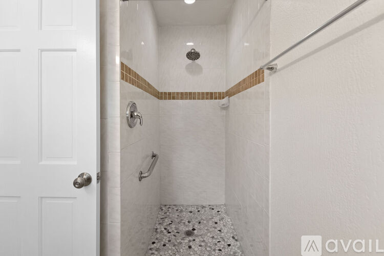 A white bathroom with a shower and a door.
