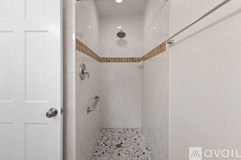 A white bathroom with a shower and a door.