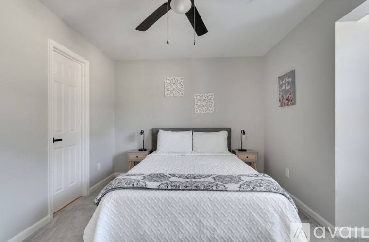 A bedroom with a large bed and a ceiling fan.