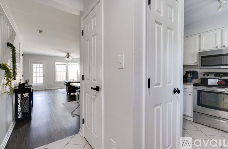 A kitchen with white cabinets and a black stove top oven.