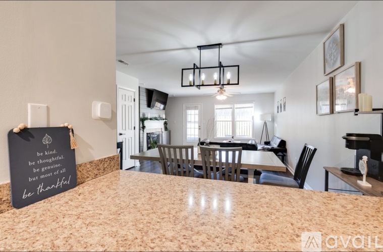 A dining room with a table set for four and a chalkboard with a message on it.