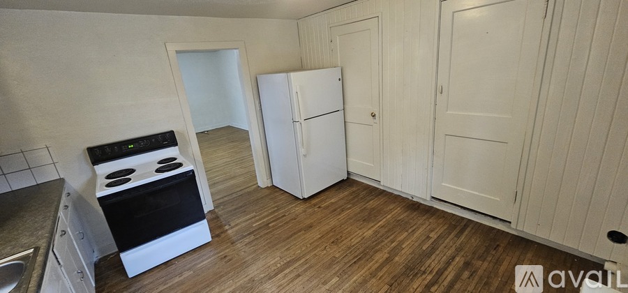 A kitchen with a stove, refrigerator, and cabinets.