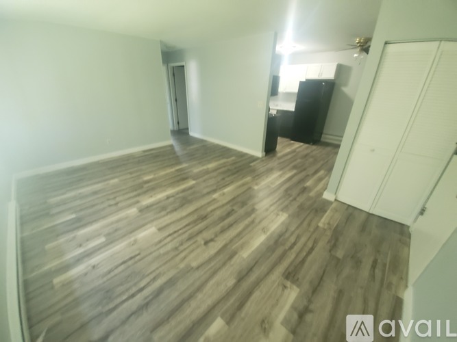 A room with wooden flooring and a white door.