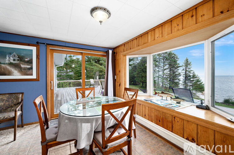 A dining room with a table and chairs and a view of the lake.