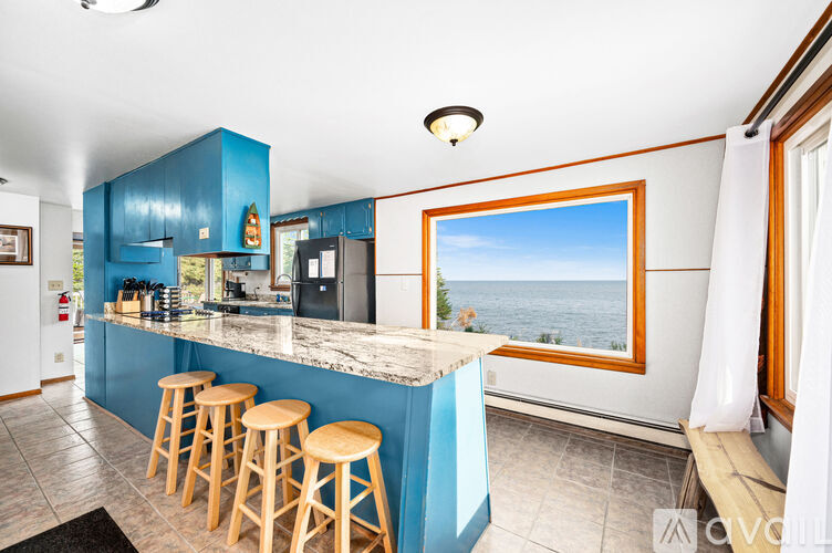 A kitchen with blue cabinets and a bar area.