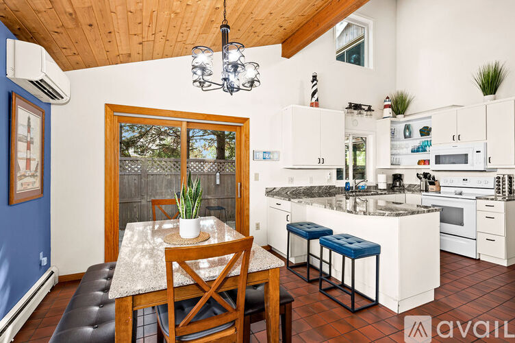 A kitchen with a table and chairs in front of a window.