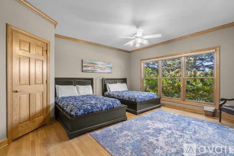 A bedroom with two beds and a ceiling fan.