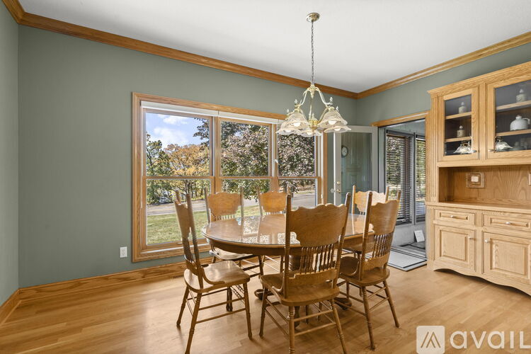 A dining room with a wooden table and chairs.