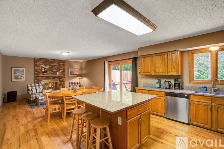 A kitchen with wooden cabinets and a stone fireplace.