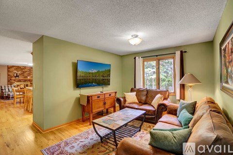A living room with a couch, chairs, and a painting on the wall.