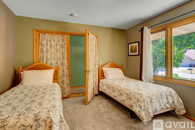A bedroom with two beds and a window.