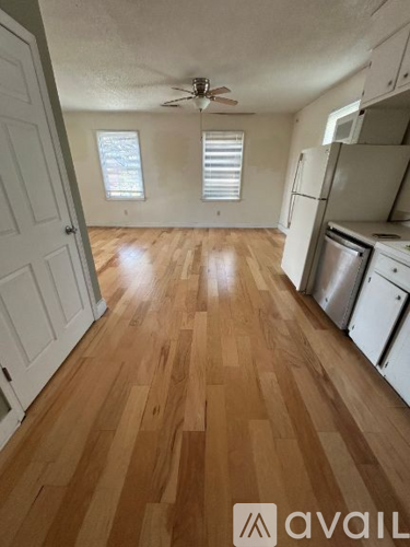 A kitchen with wooden floors and white appliances.