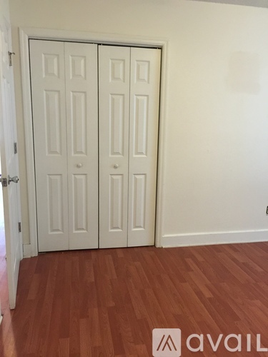 A room with two white doors and a wooden floor.
