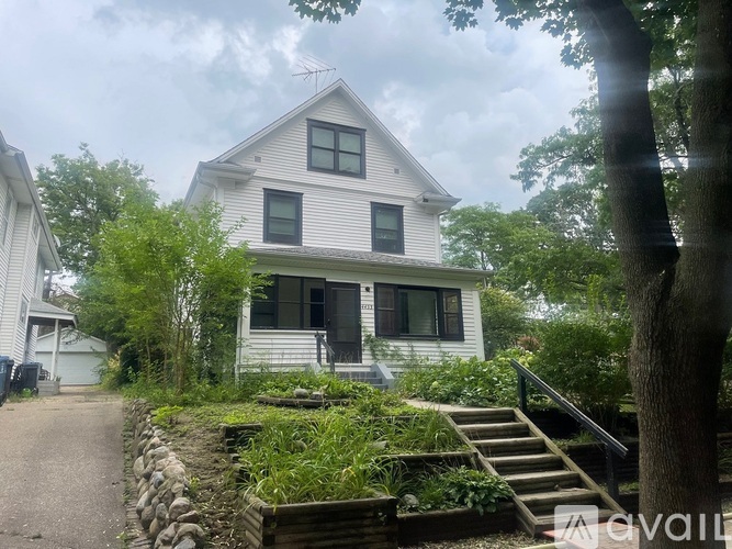 A white house with a grey roof and a small porch.