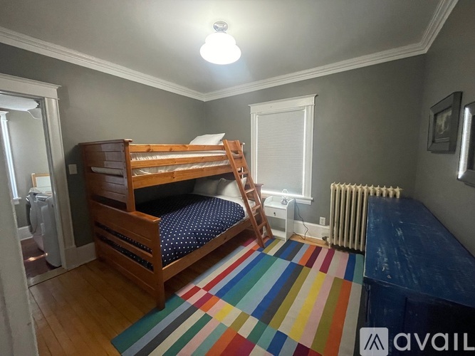 A bedroom with a bunk bed and a striped rug.