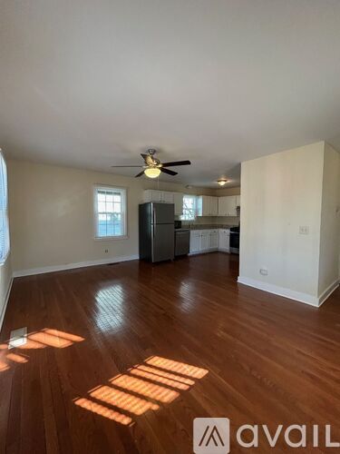 A room with wooden floors and a ceiling fan.