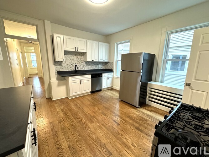 A kitchen with wooden floors and a black stove top.