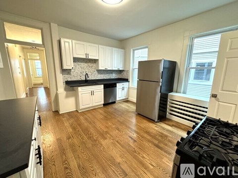 A kitchen with wooden floors and a black stove top.