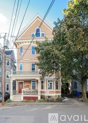 A two-story house with a red door and a porch.