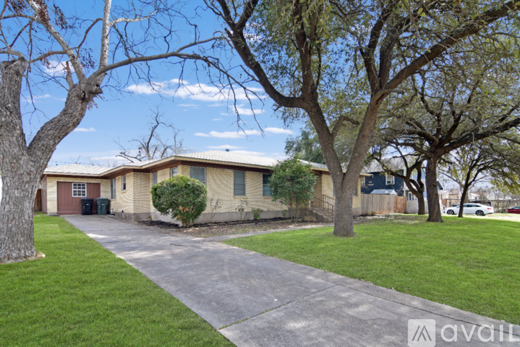 A house with a driveway and trees in front.